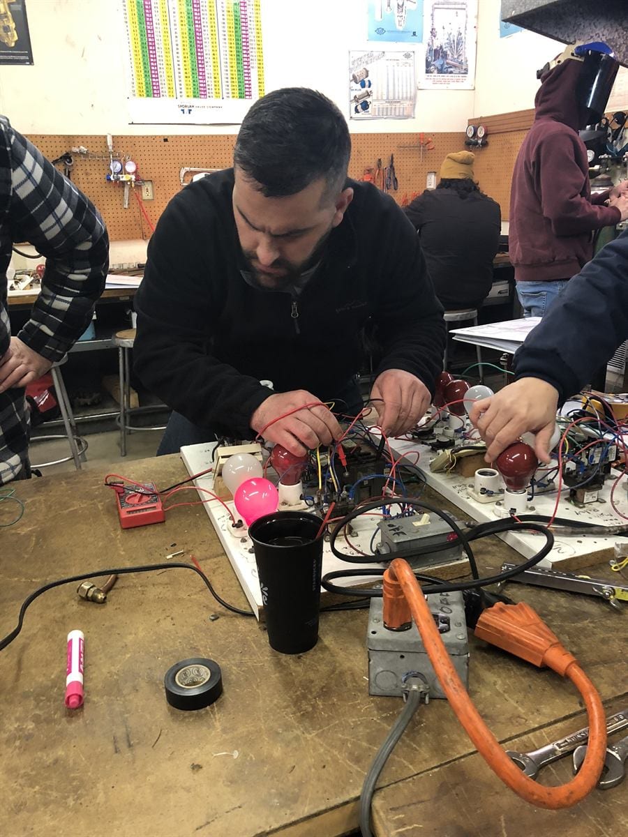 ACHP 106 student running diagnostics on heat pump training equipment