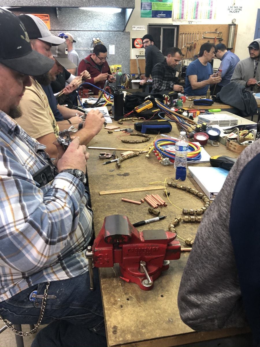 ACHP 106 student wiring an air handler at the training bench