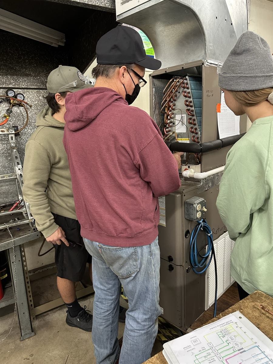 ACHP 106 group reviewing a wiring diagram at the bench